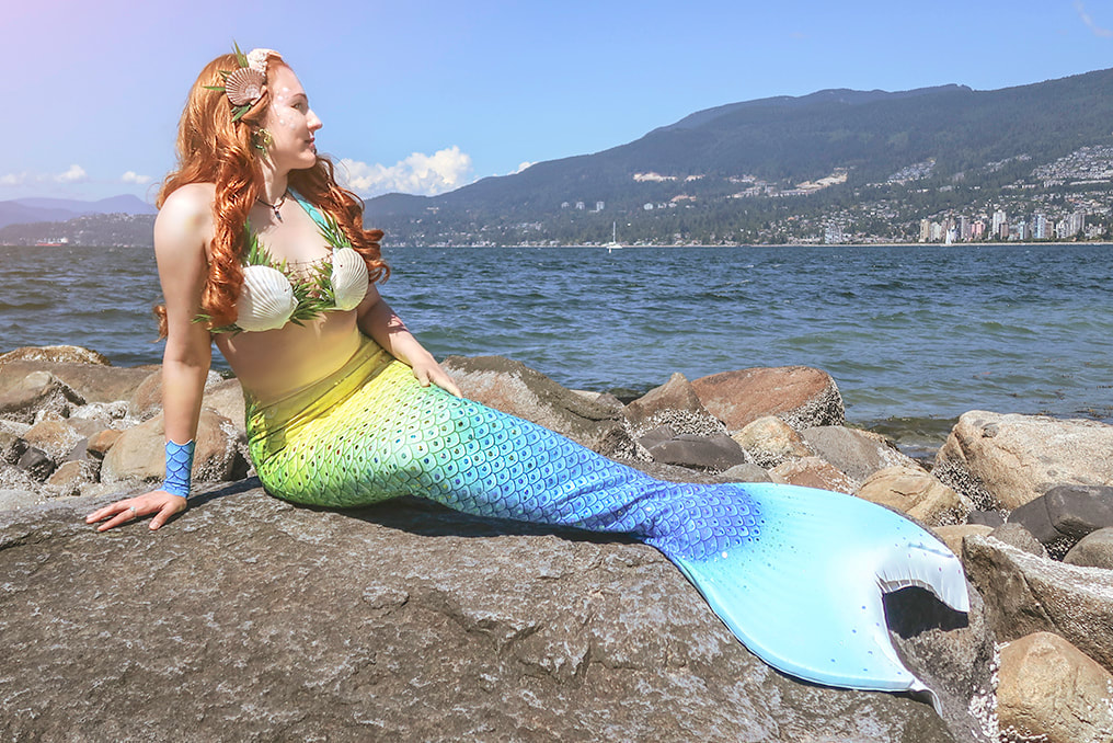 Courtney the Vancouver Mermaid on some rocks in Stanley Park